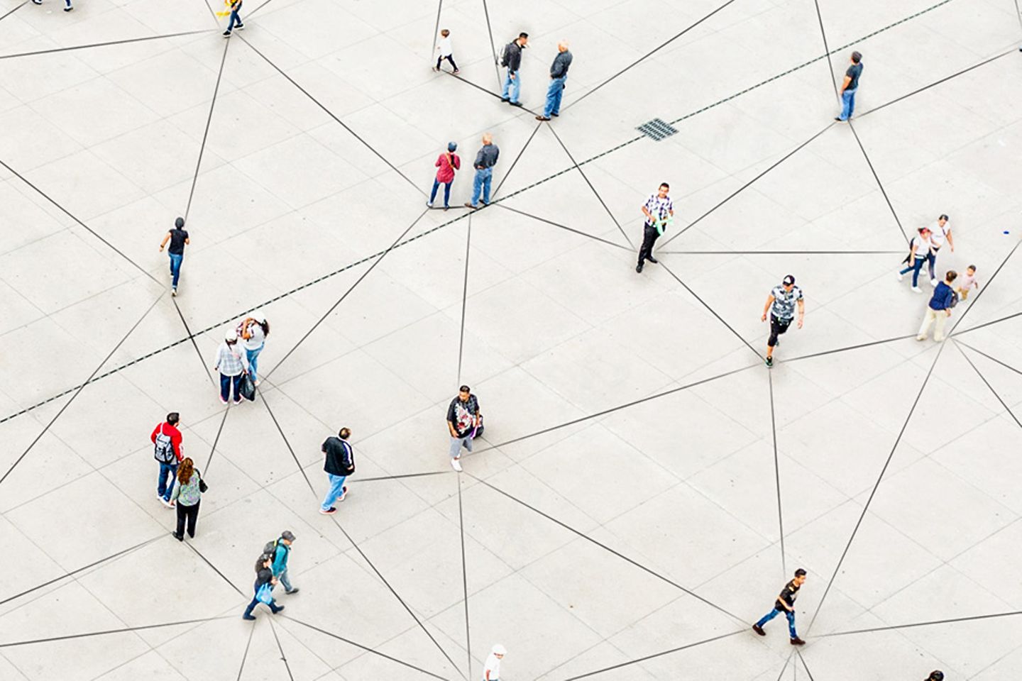 Picture from bird's eye view shows many people in small groups. The lines on the ground connect these groups.