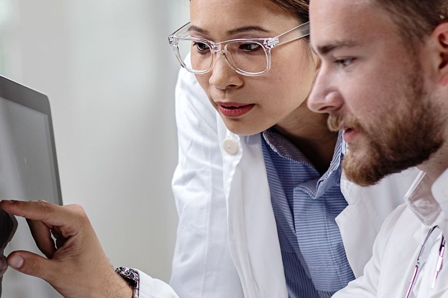 Two doctors analyze data on a screen