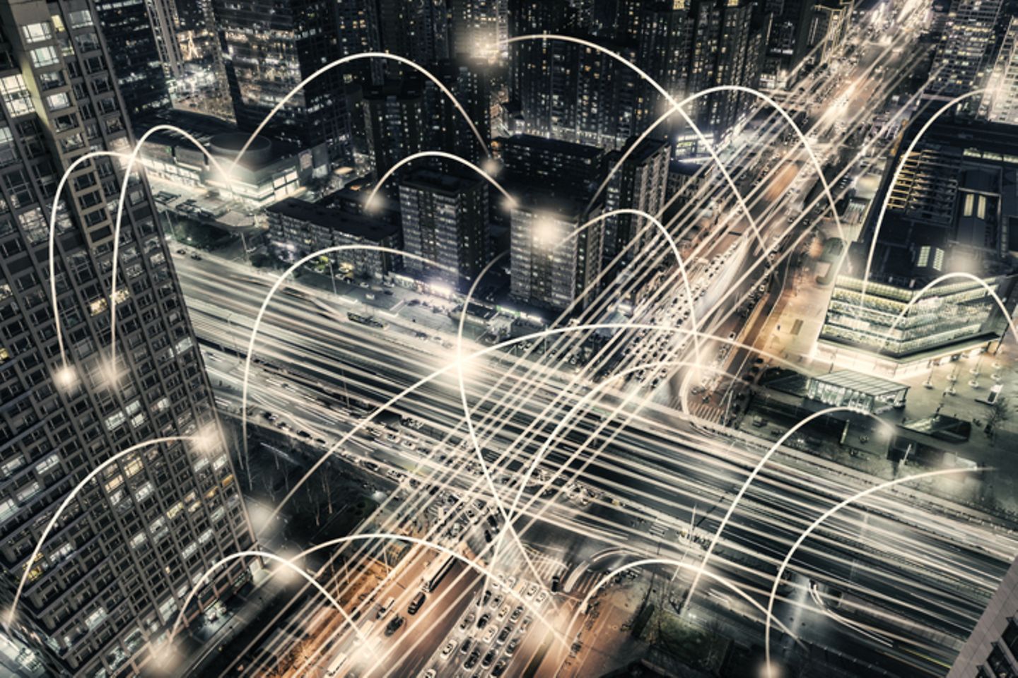 Bird's eye view of a road junction at night in a city, where lines connect different points of light