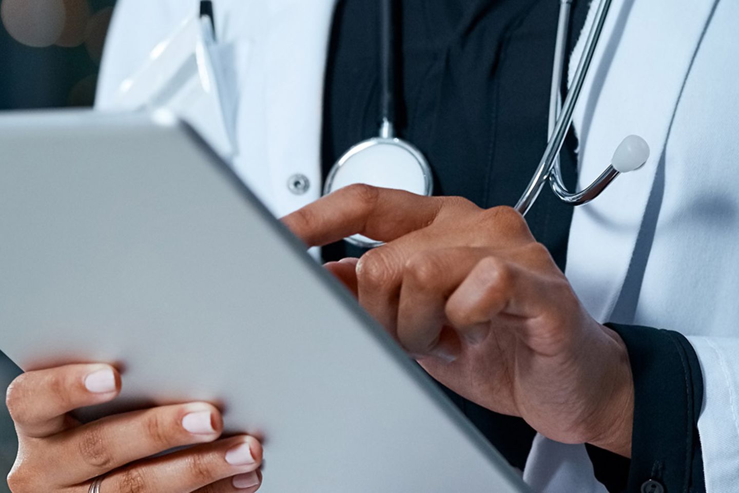 A doctor holds a tablet in her hand.