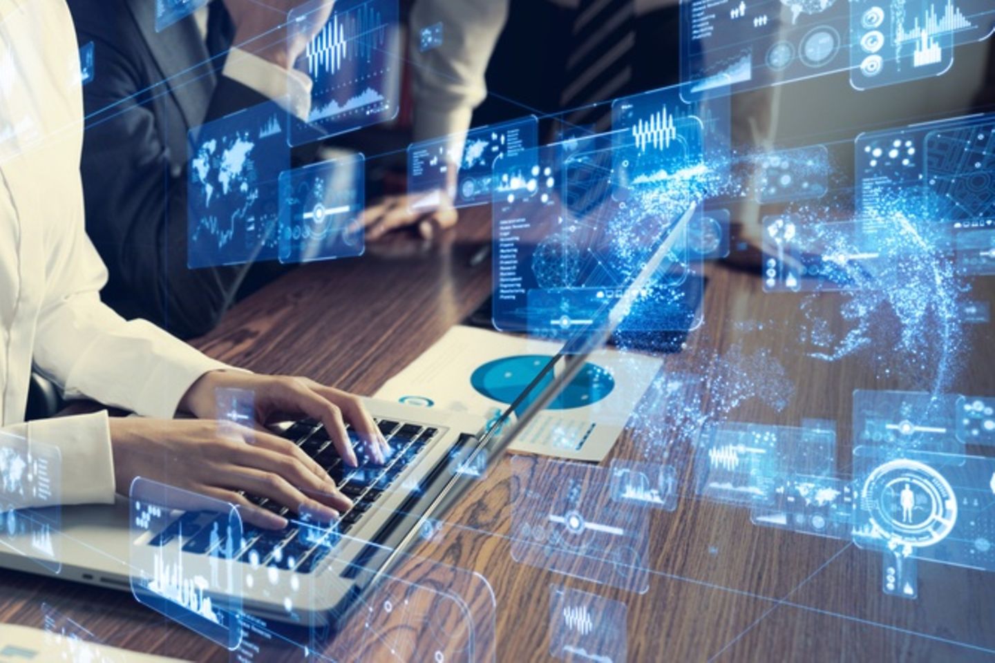 Person typing on a laptop, digital graphics float in the foreground