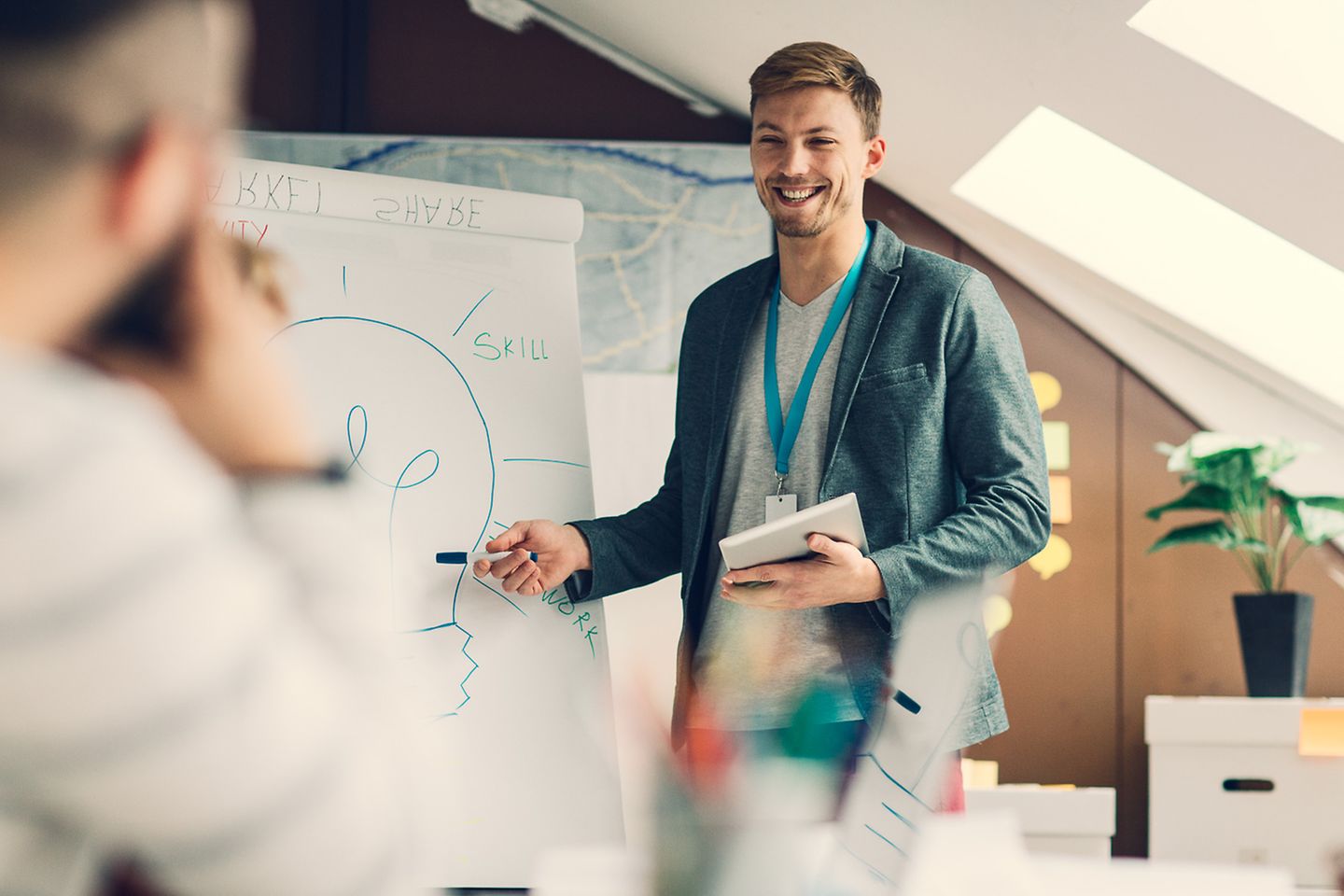 Young man presents his colleagues an idea on a whiteboard