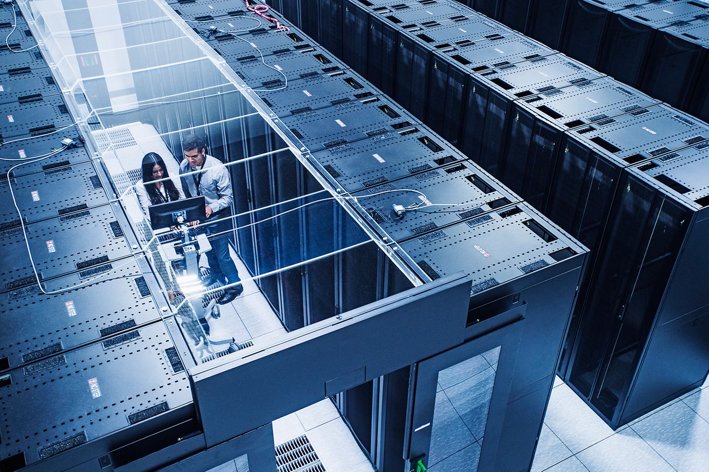 High angle view of technicians in front of a series of server racks