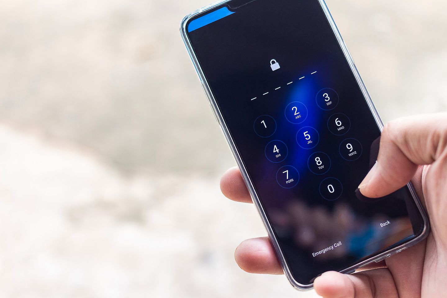 A hand types in a PIN on a smartphone