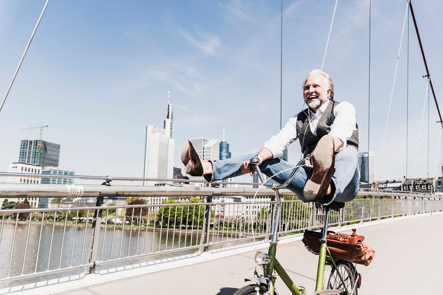 Man is cycling in front of a skyline.