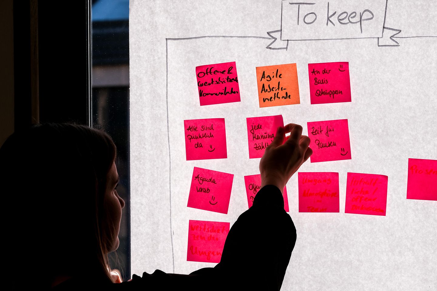 Vrouw plakt post-its op een flipchart