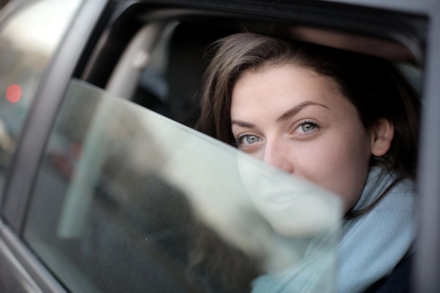 Una mujer mirando por la ventana de un automóvil