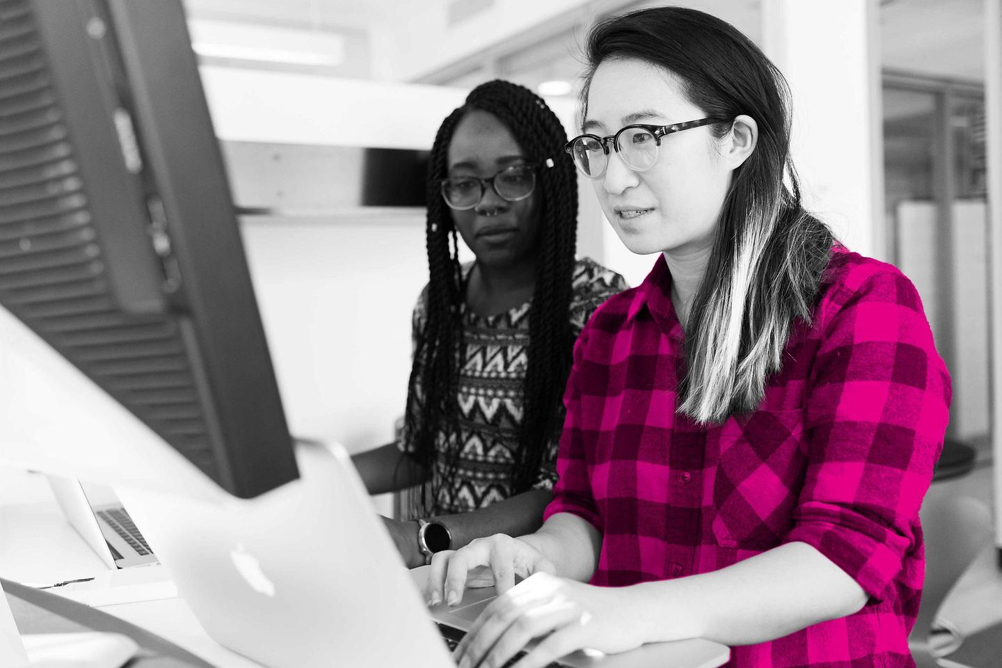 Dos mujeres jóvenes trabajan frente a un PC