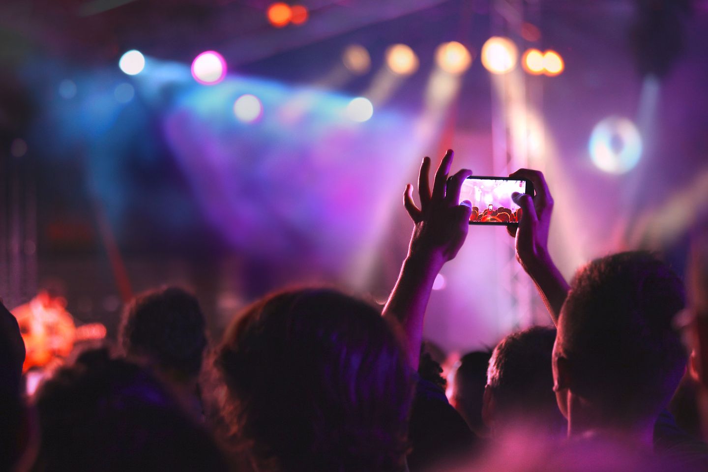 Un hombre haciendo una foto con su móvil en un evento