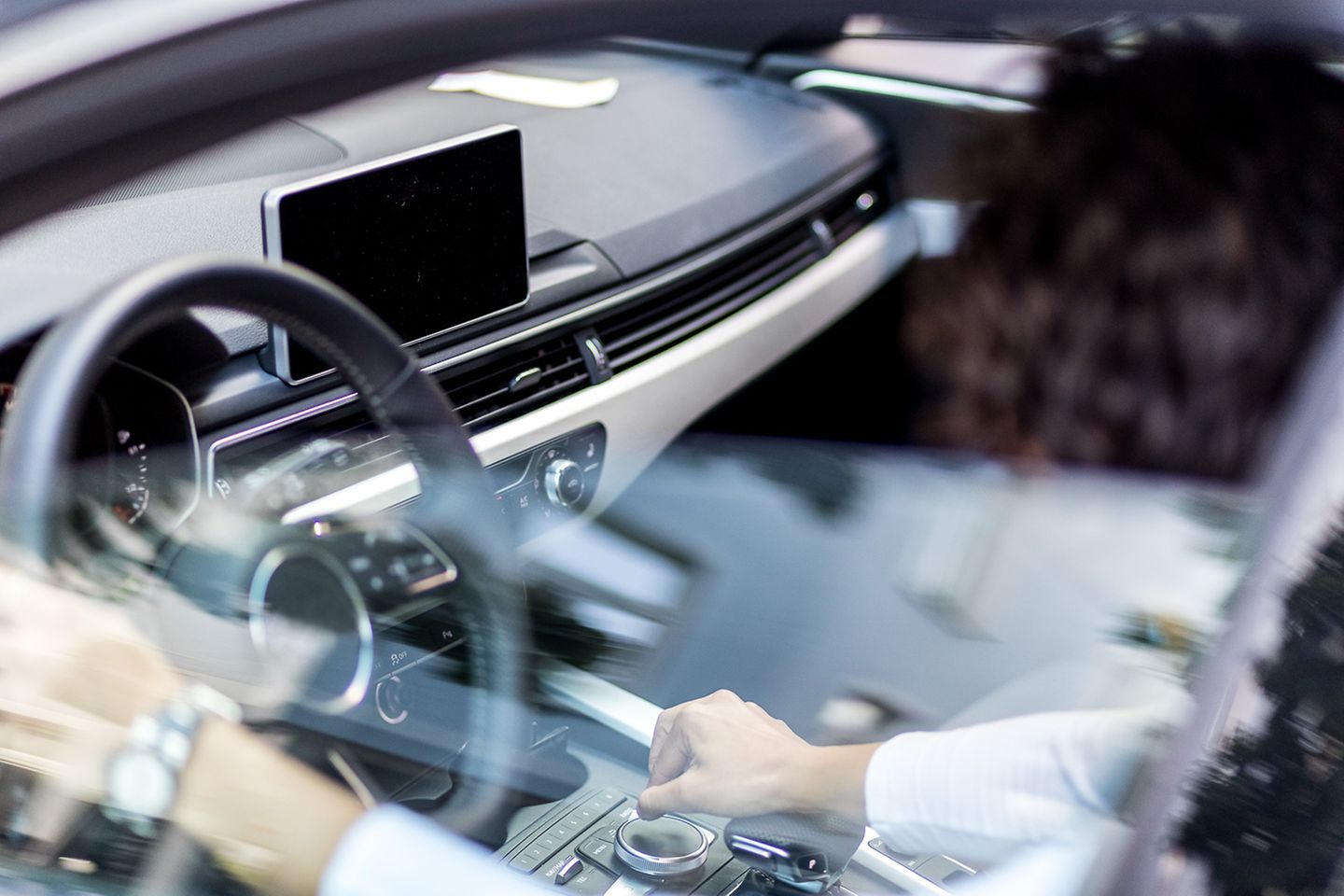 Blurred shot of a person sitting at the wheel of a car.