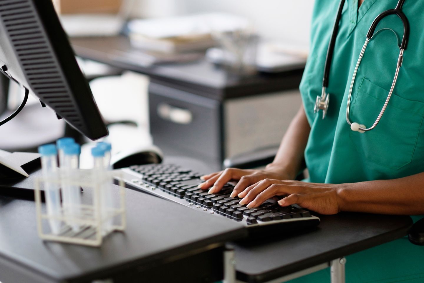 A nurse works at a computer