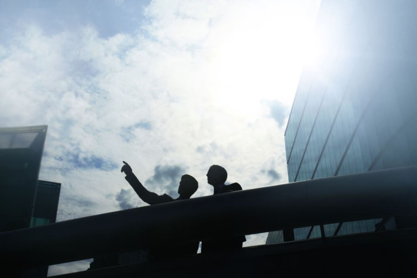 Deux personnes se tiennent sur le balcon d'un immeuble de bureaux.