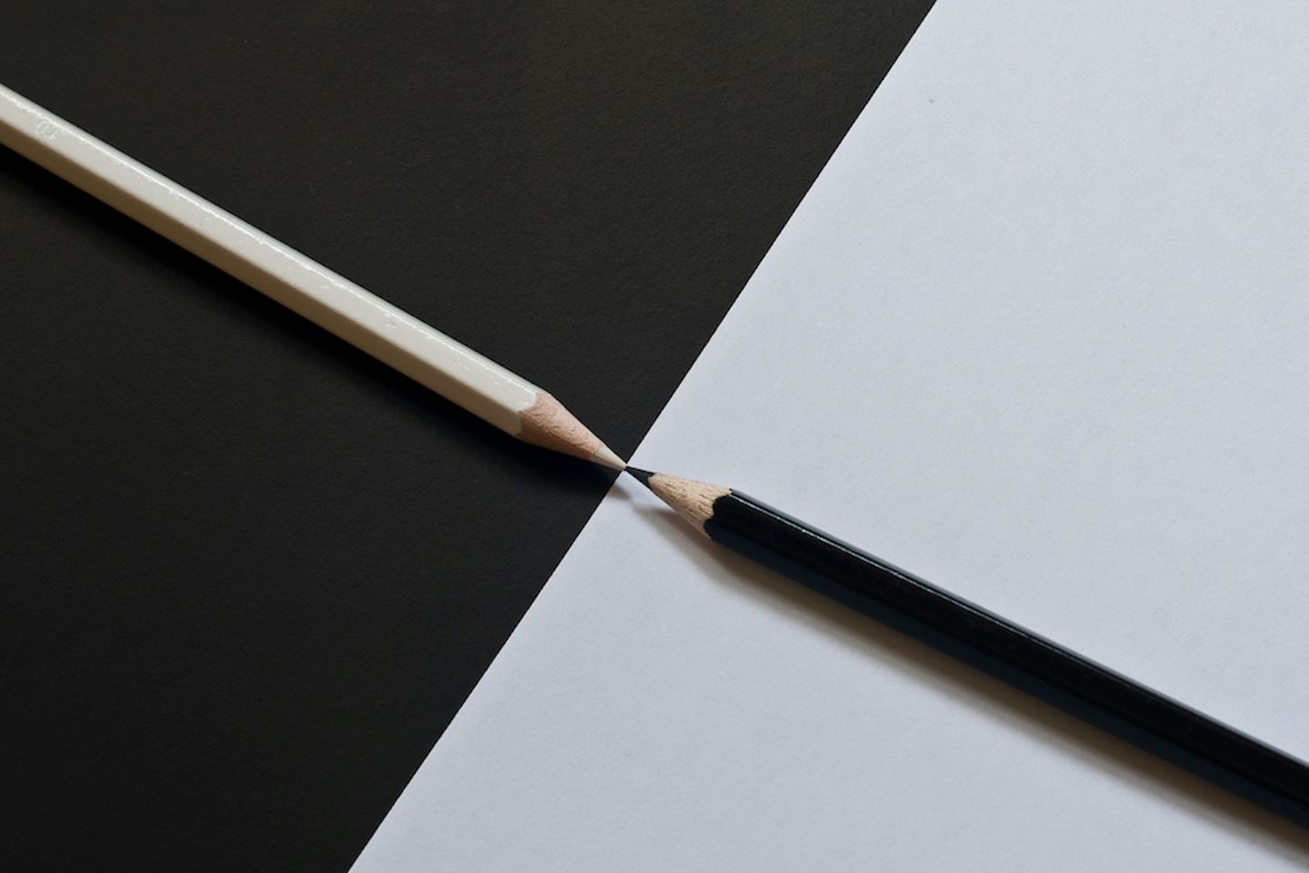 Ein schwarzer und ein weißer Stift berühren sich