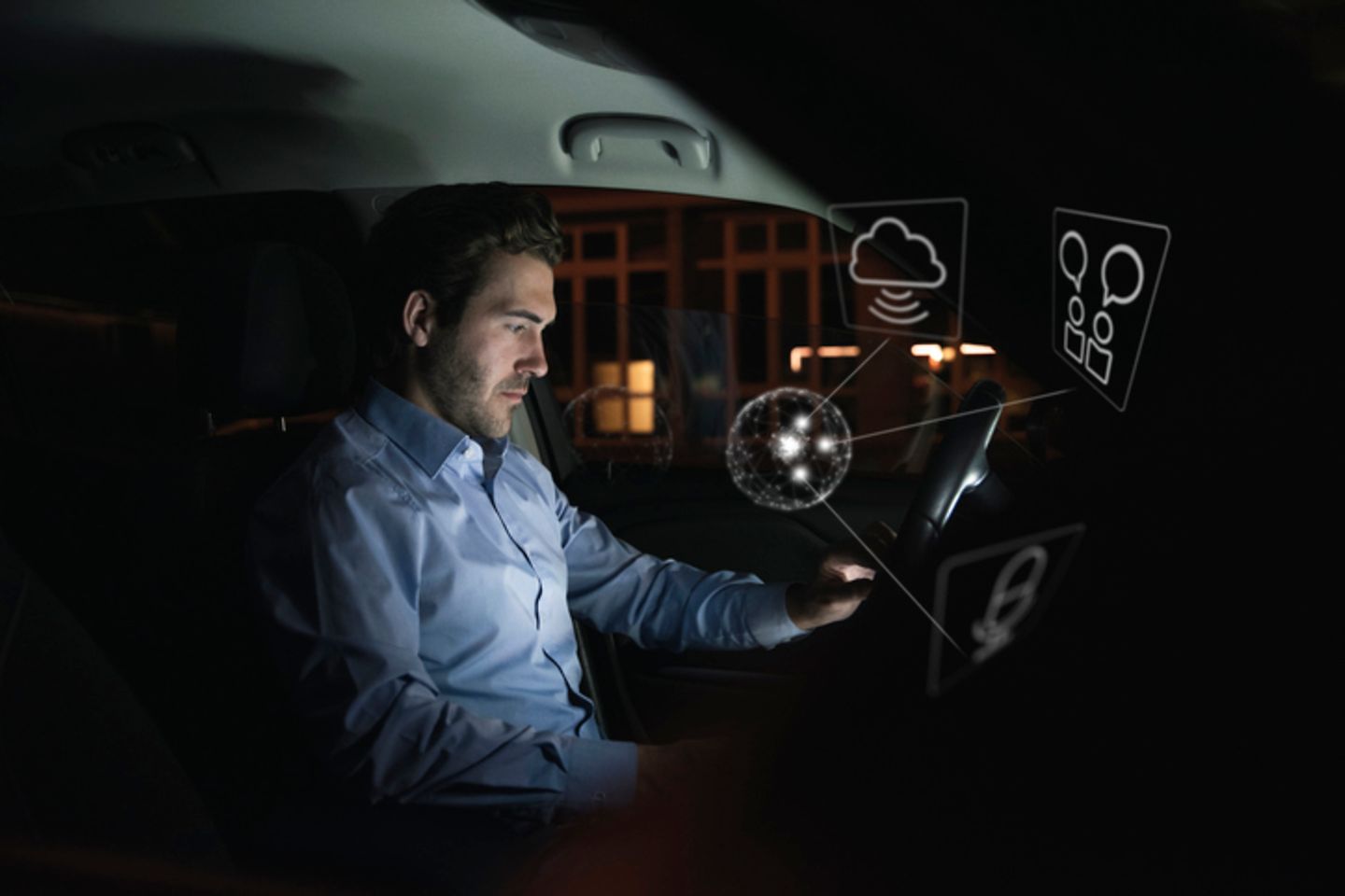 Ein Mann benutzt nachts im Auto ein Gerät, umgeben von Internet-Symbolen