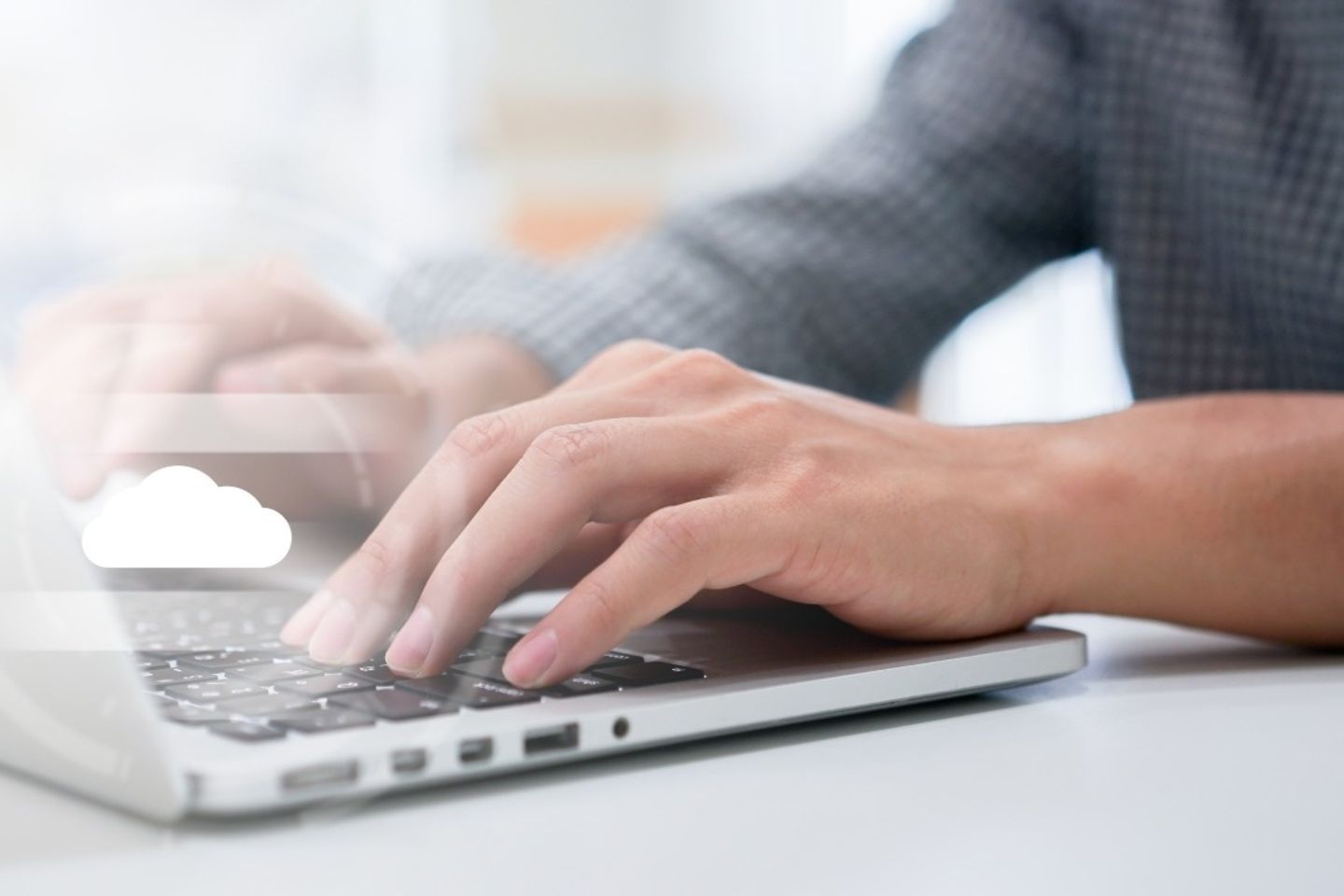 Hands typing on laptop keyboard