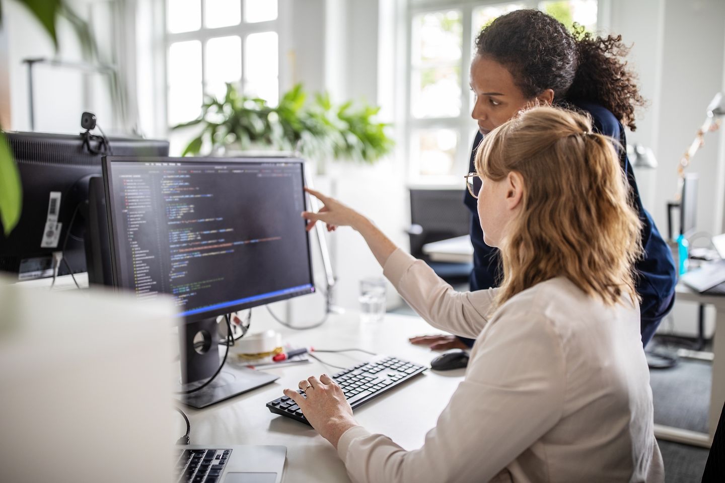 Colleagues having a discussion in front of a monitor.