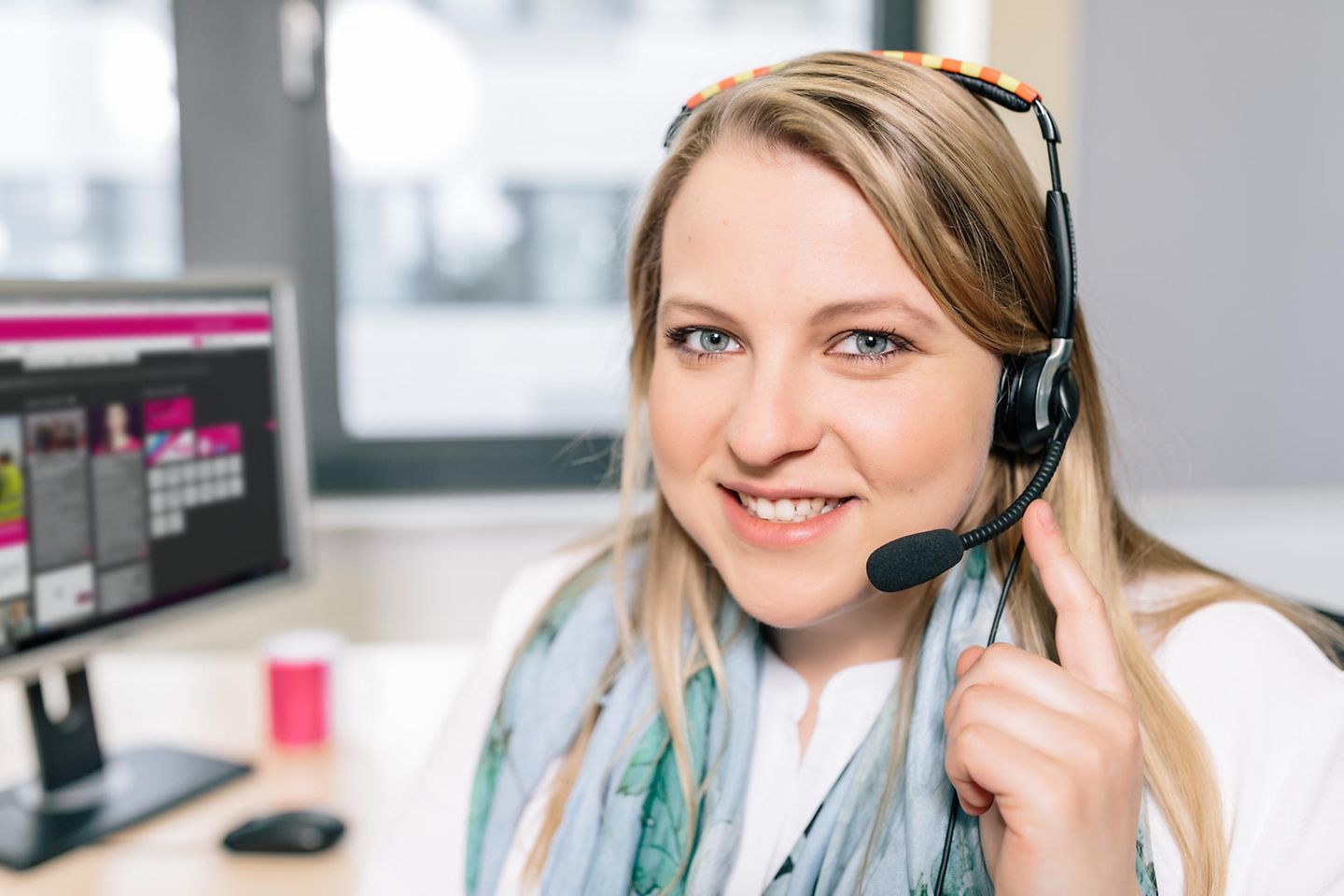 Auszubildende telefoniert mit dem Headset im Büro