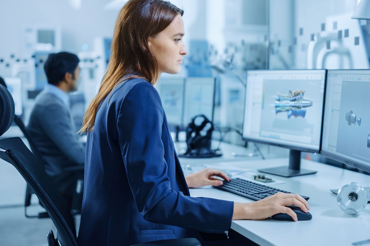 Woman working on laptop next to colleague