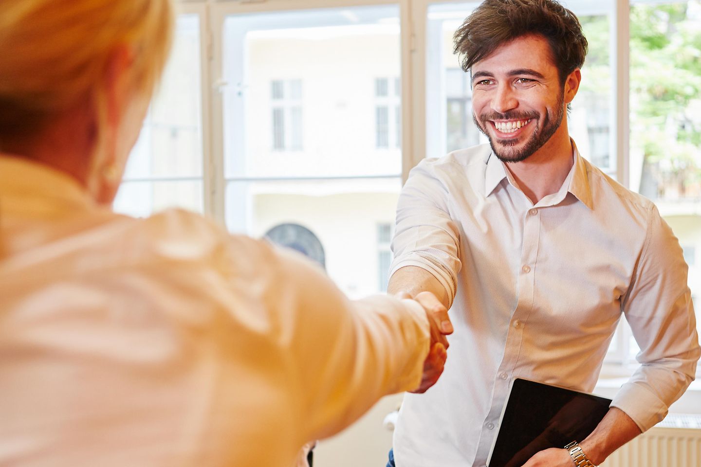 Frau und Mann händeschüttelnd im Büro