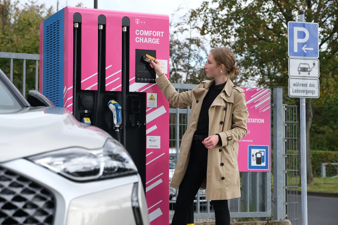 Een vrouw houdt een kaart voor een laadstation