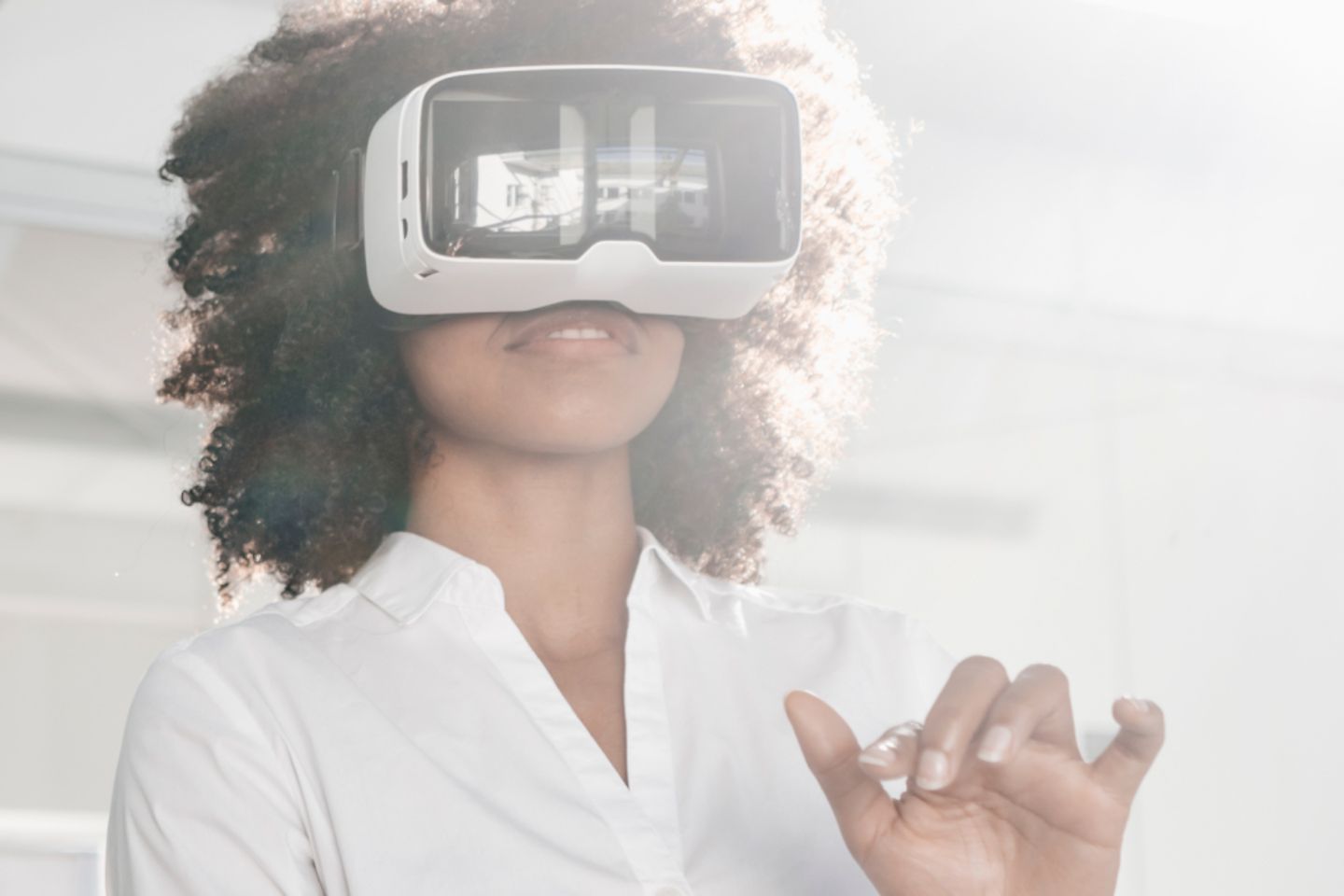 Woman standing in the room wearing AR glasses.