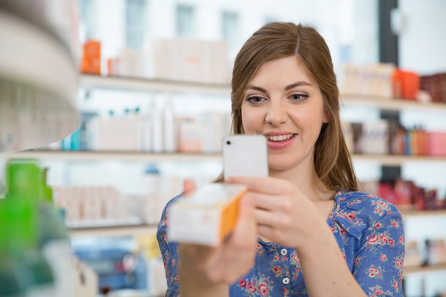 Frau scannt im Laden den Barcode eines Produkts