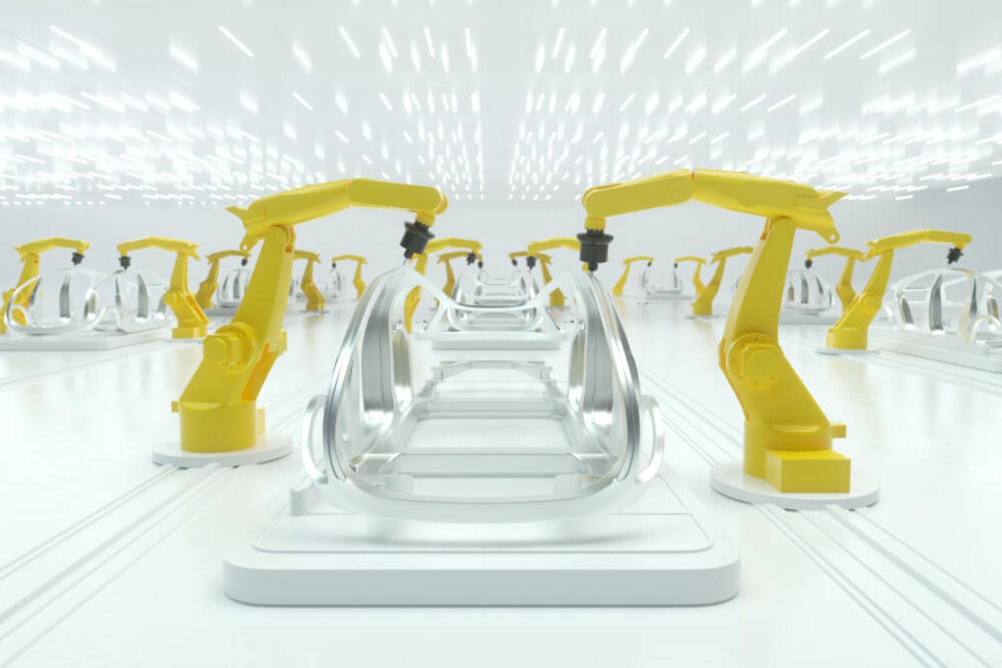 braços robóticos amarelos trabalham na construção de uma carroceria