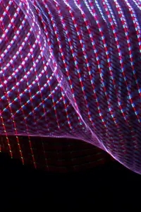 Uma rede fluida com uma luz magenta, lilás e azul com um plano de fundo preto.