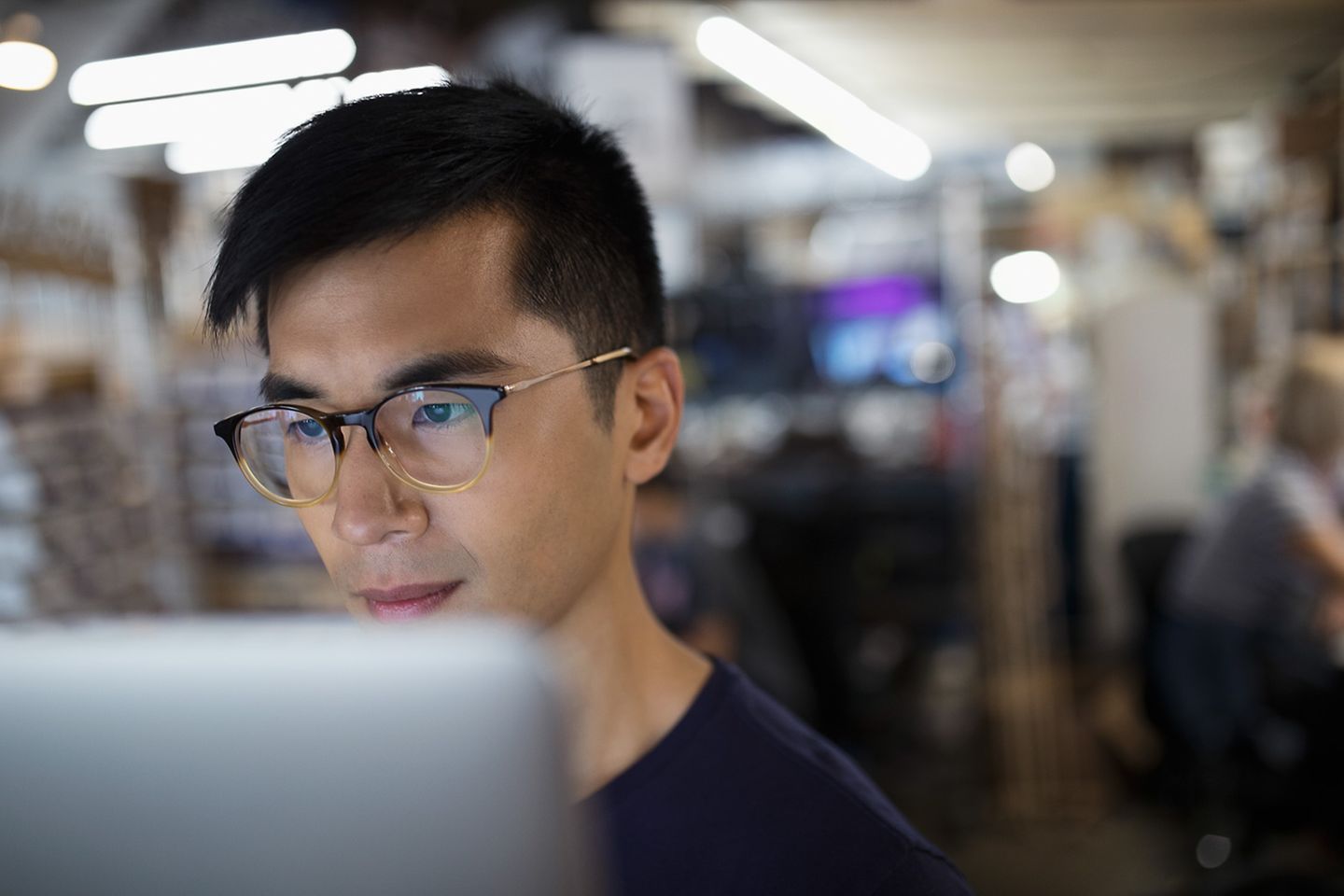 Hombre joven trabajando concentrado con el portátil en unas instalaciones de investigación