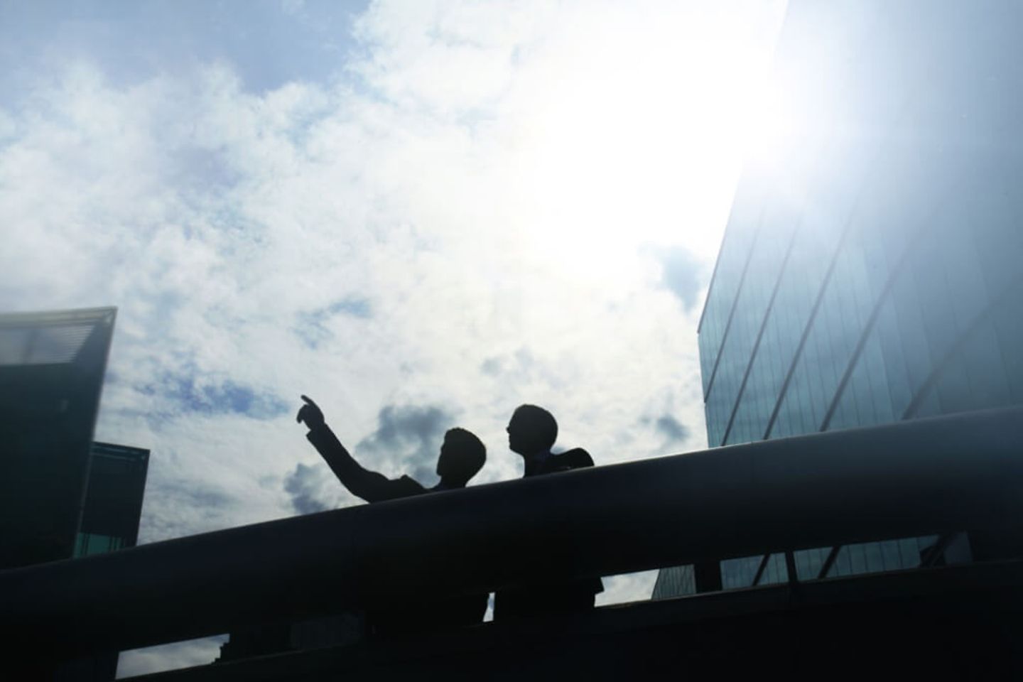 Two people are standing on the balcony of an office building.