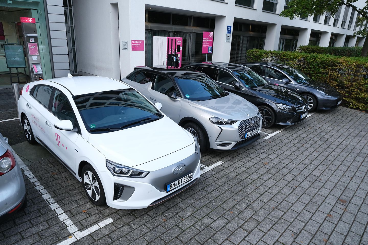 Quatre voitures garées côte à côte sur un parking