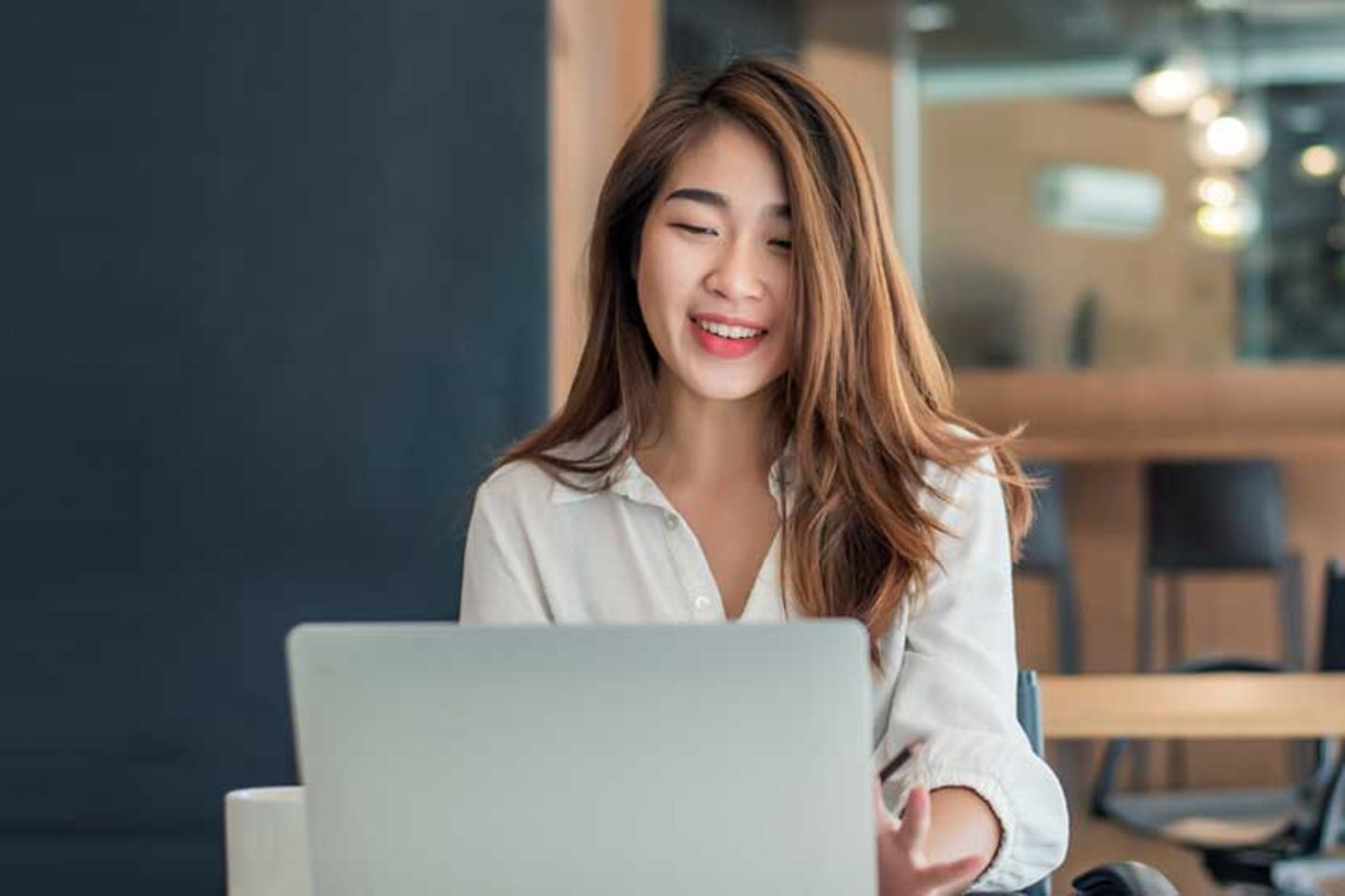 Asian businesswoman sitting working on laptop in office