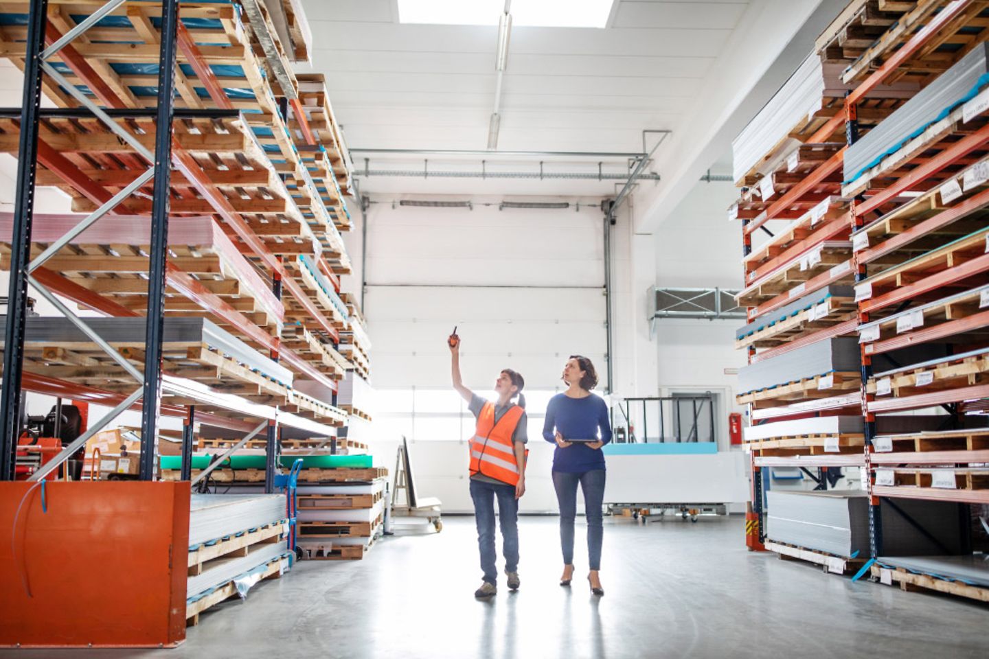 Two women walk through a warehouse.