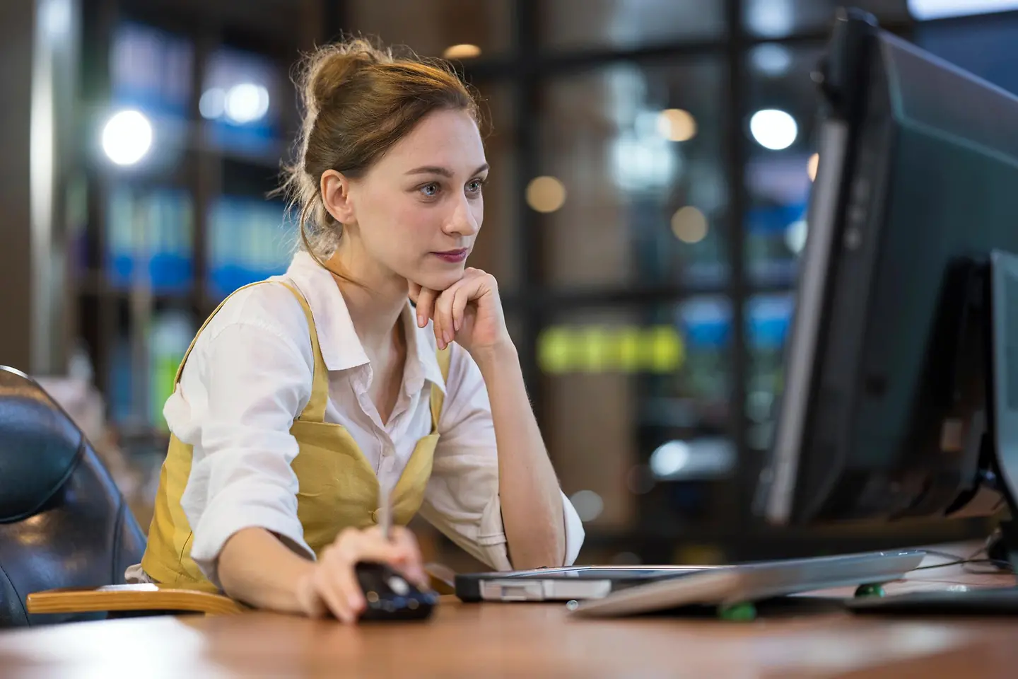 Porträt einer Frau, die im Büro am Laptop arbeitet