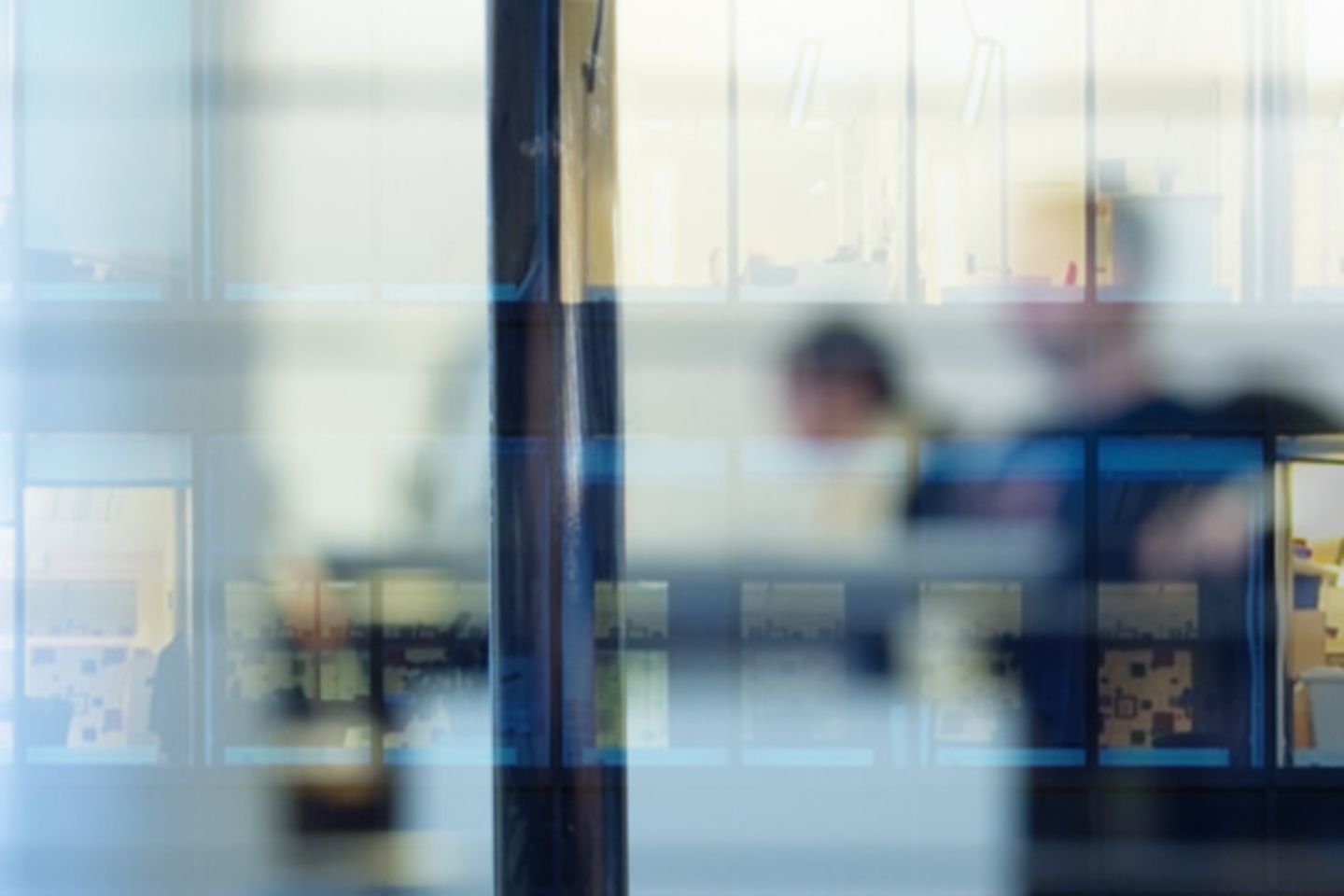 Reflection of people working through a window 