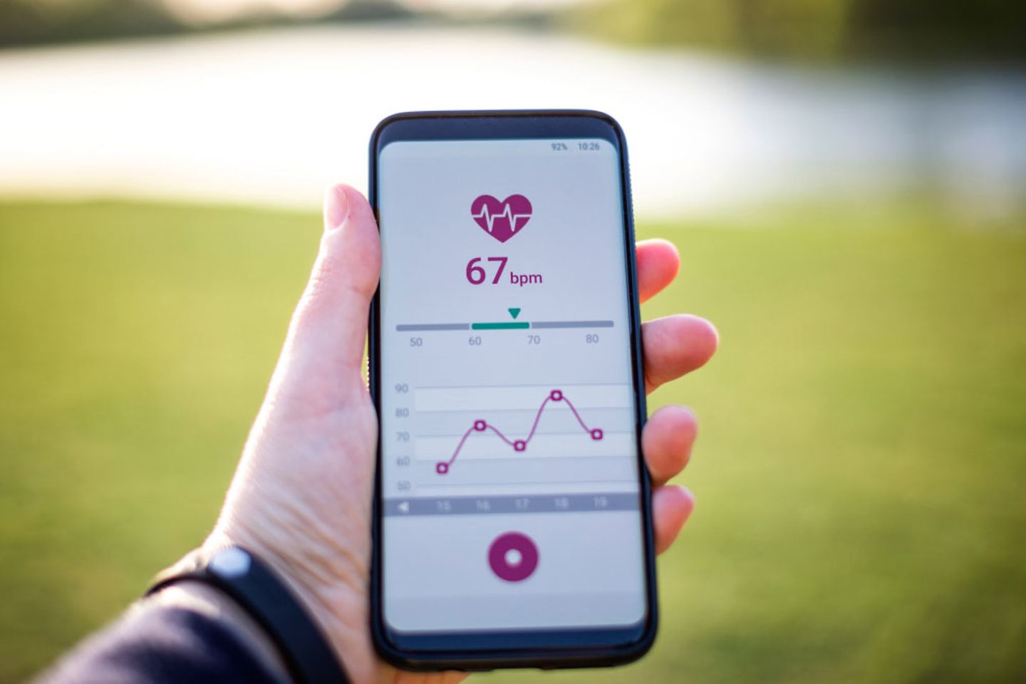 A hand holding a phone which shows health data