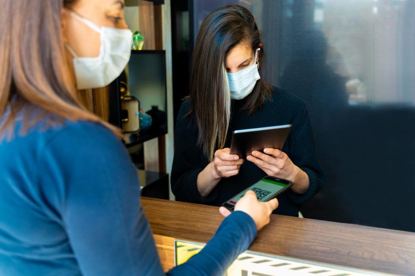 2 women scanning QR code with digital tablet.