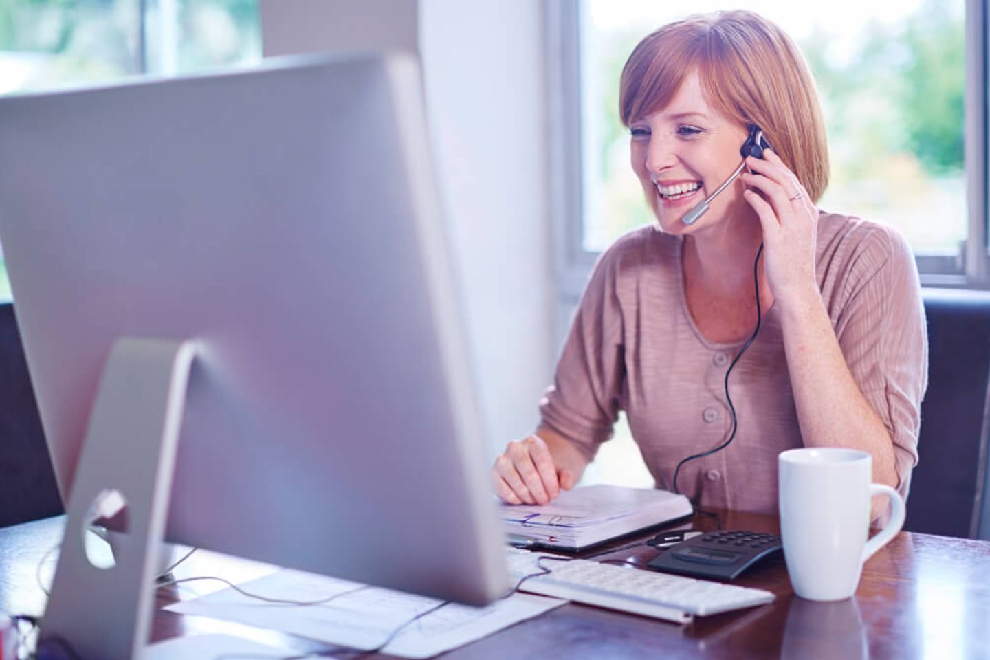 Woman at desk wearing a headset