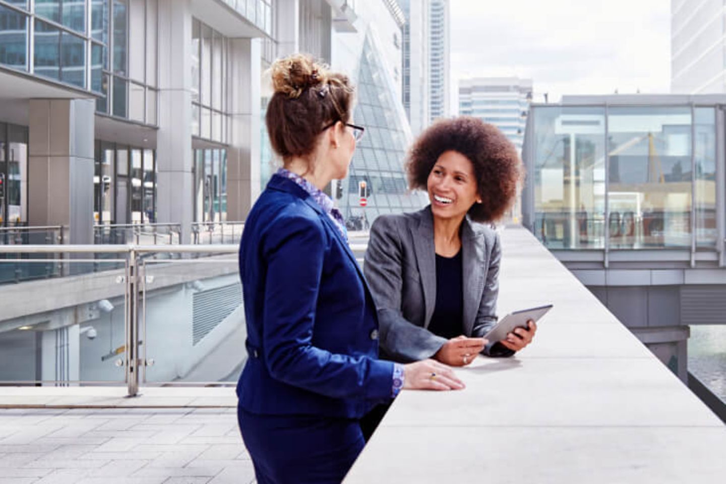 Zwei Business-Frauen vor modernem Gebaude