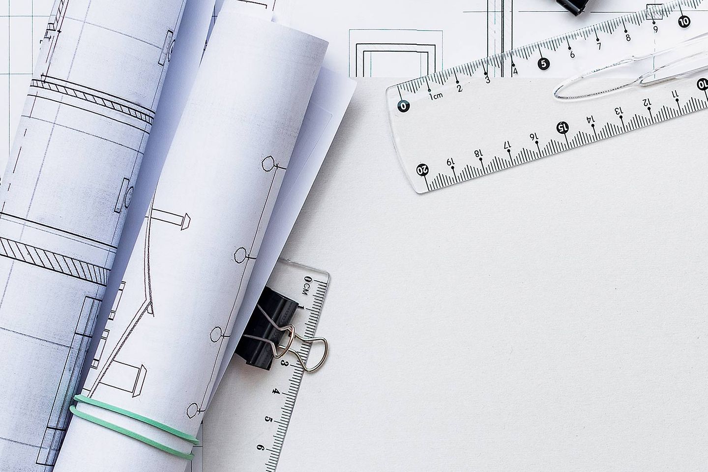 Weißes Papier mit Linealen, Geodreiecken und Papierrollen