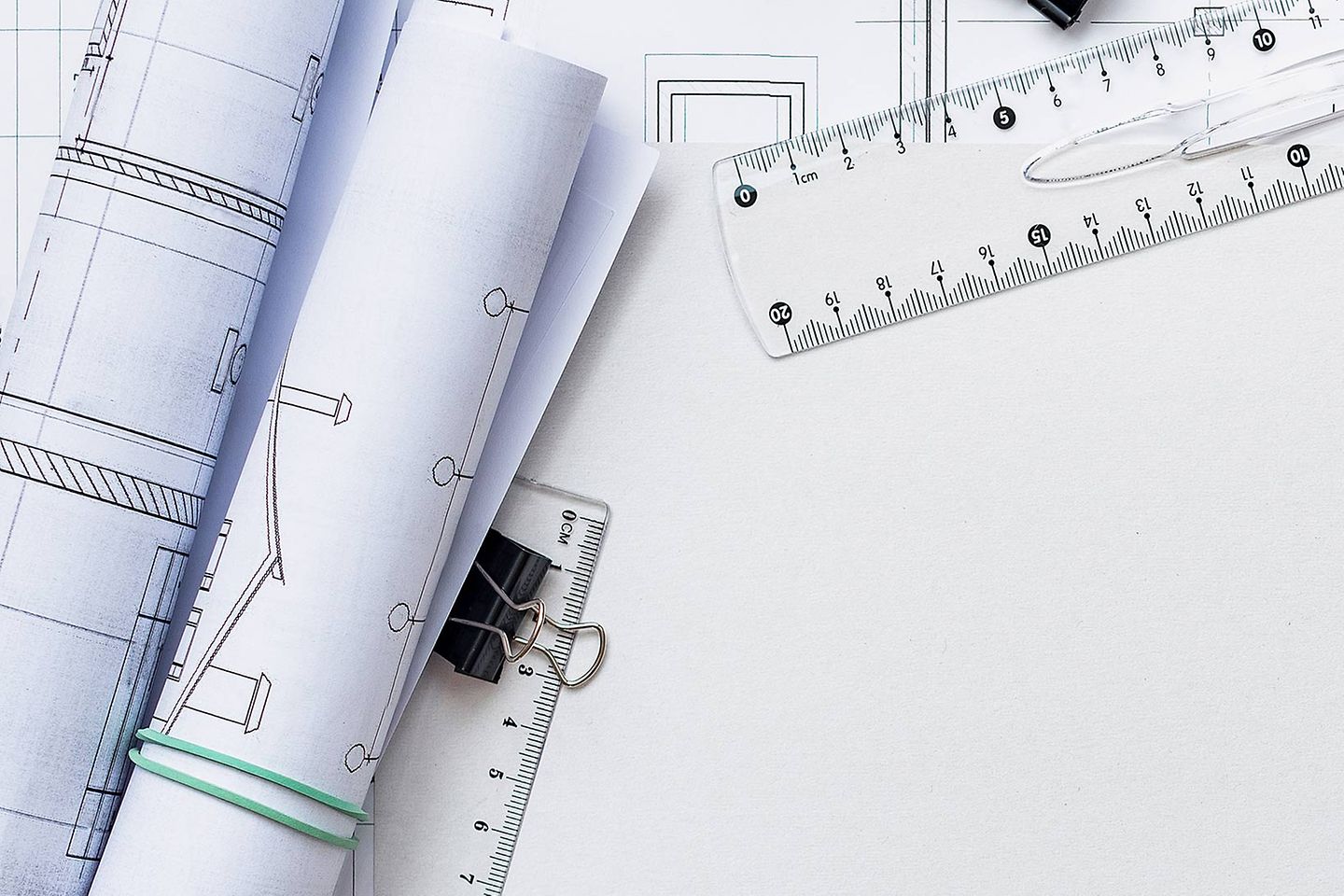 Weißes Papier mit Linealen, Geodreiecken und Papierrollen