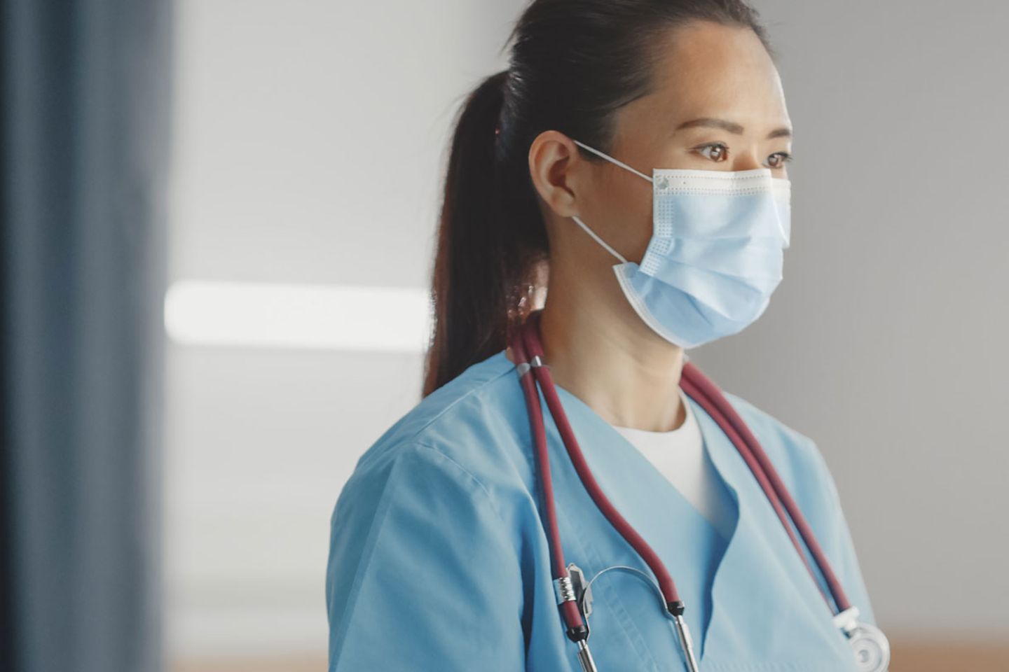 doctor wearing face mask uses medical computer, checking patient's medical data