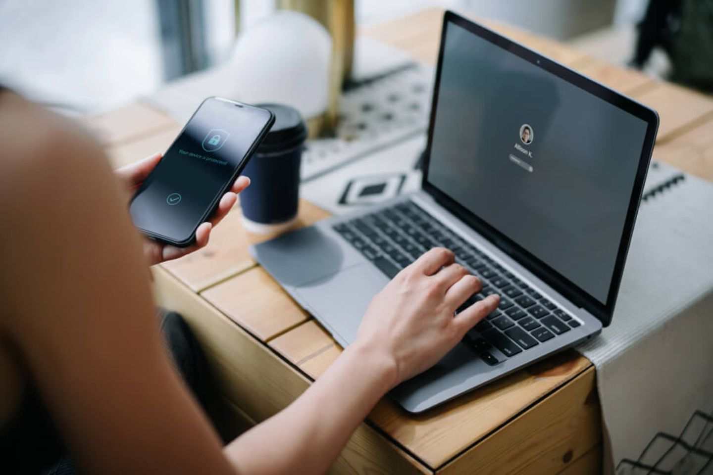 Person using smartphone and laptop at the same time