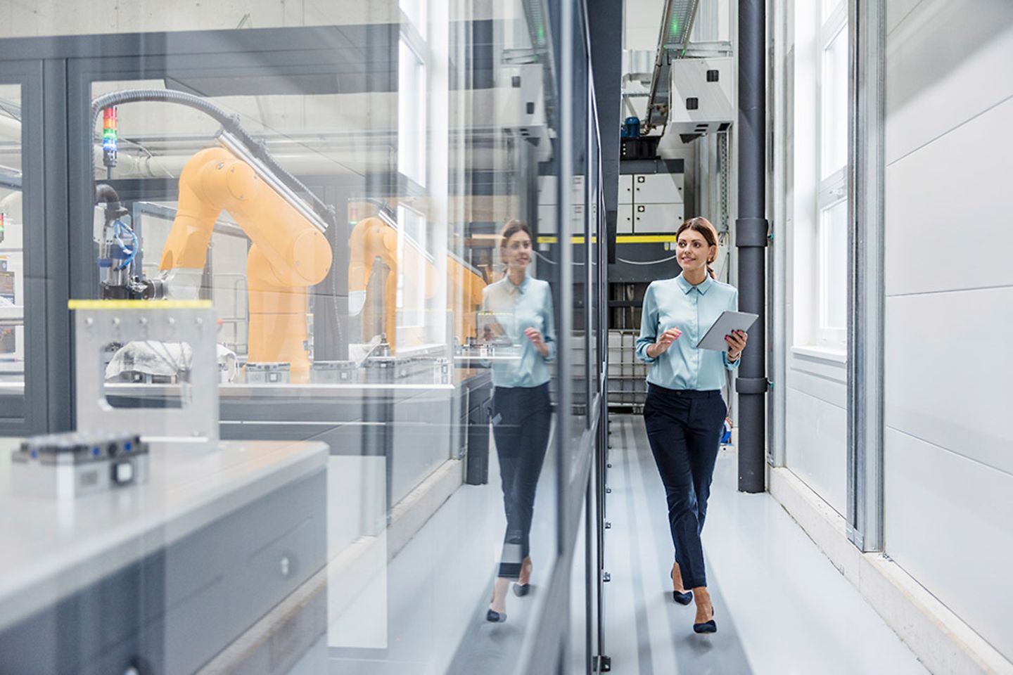 Businesswoman checking robots with tablet