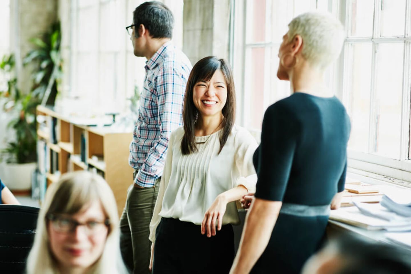 Four colleagues talking and smiling.