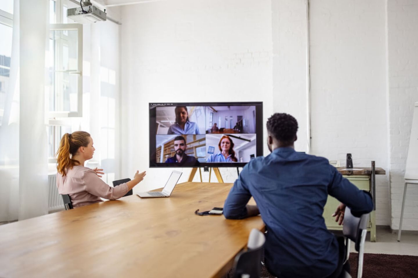 Zwei Menschen an einem Tisch zusammen in einem Videocall