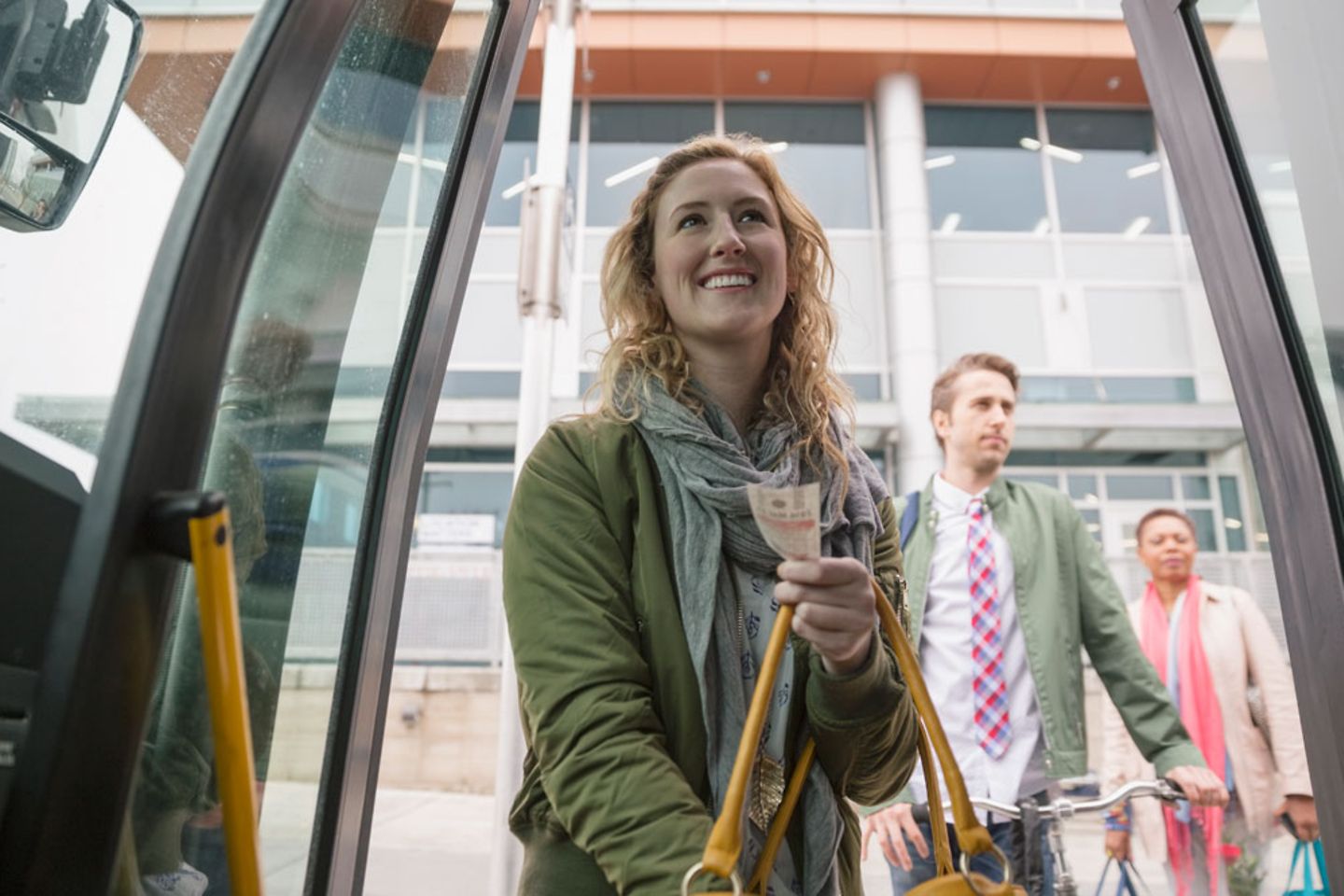 Young woman gets on a bus with a smile on her face