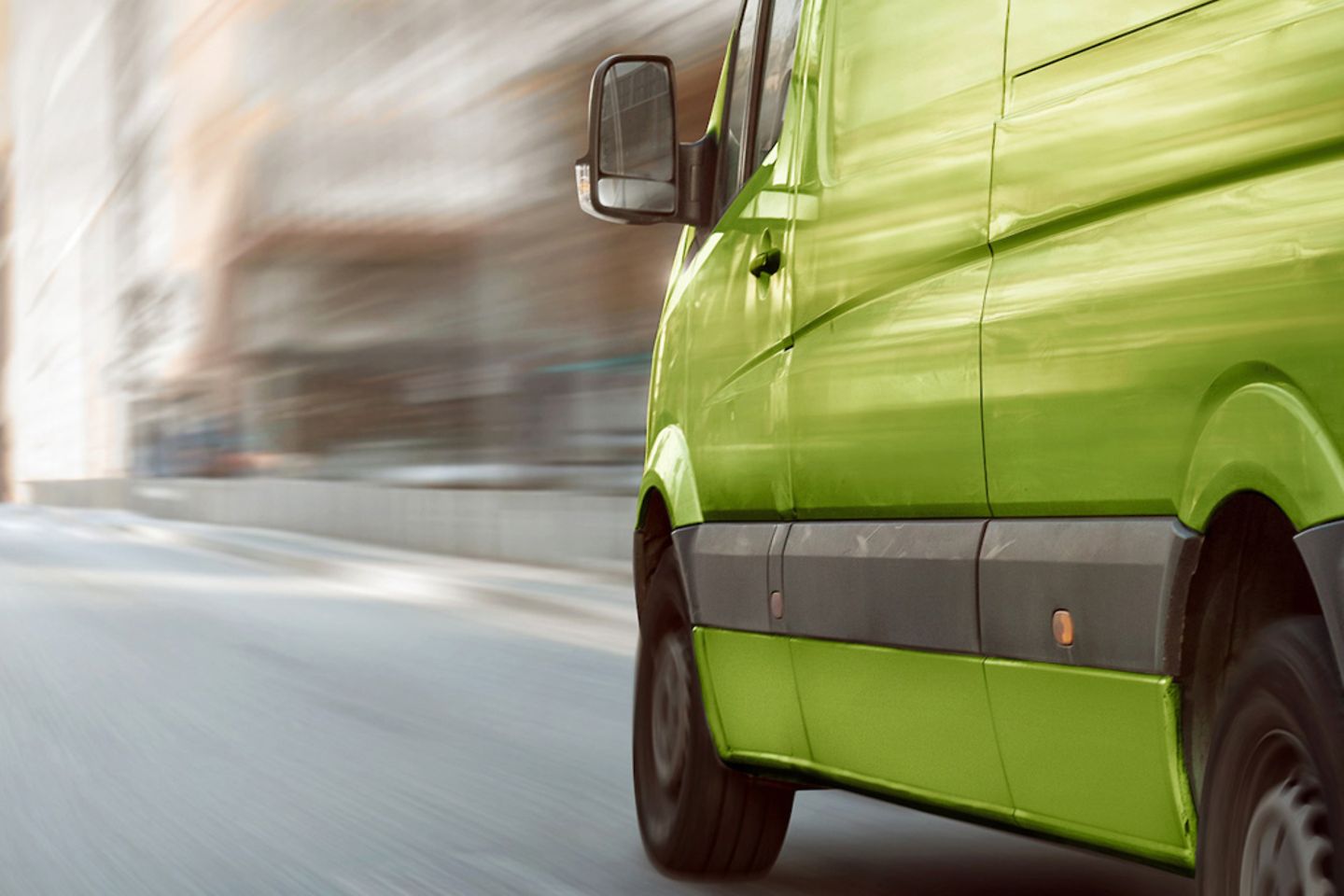 Green commercial van driving in the city