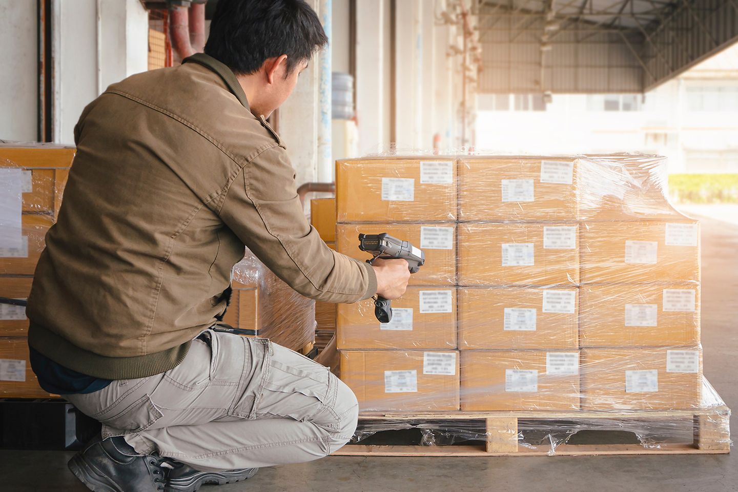Warehouse Worker Scanning Barcode Scanner on Package Box