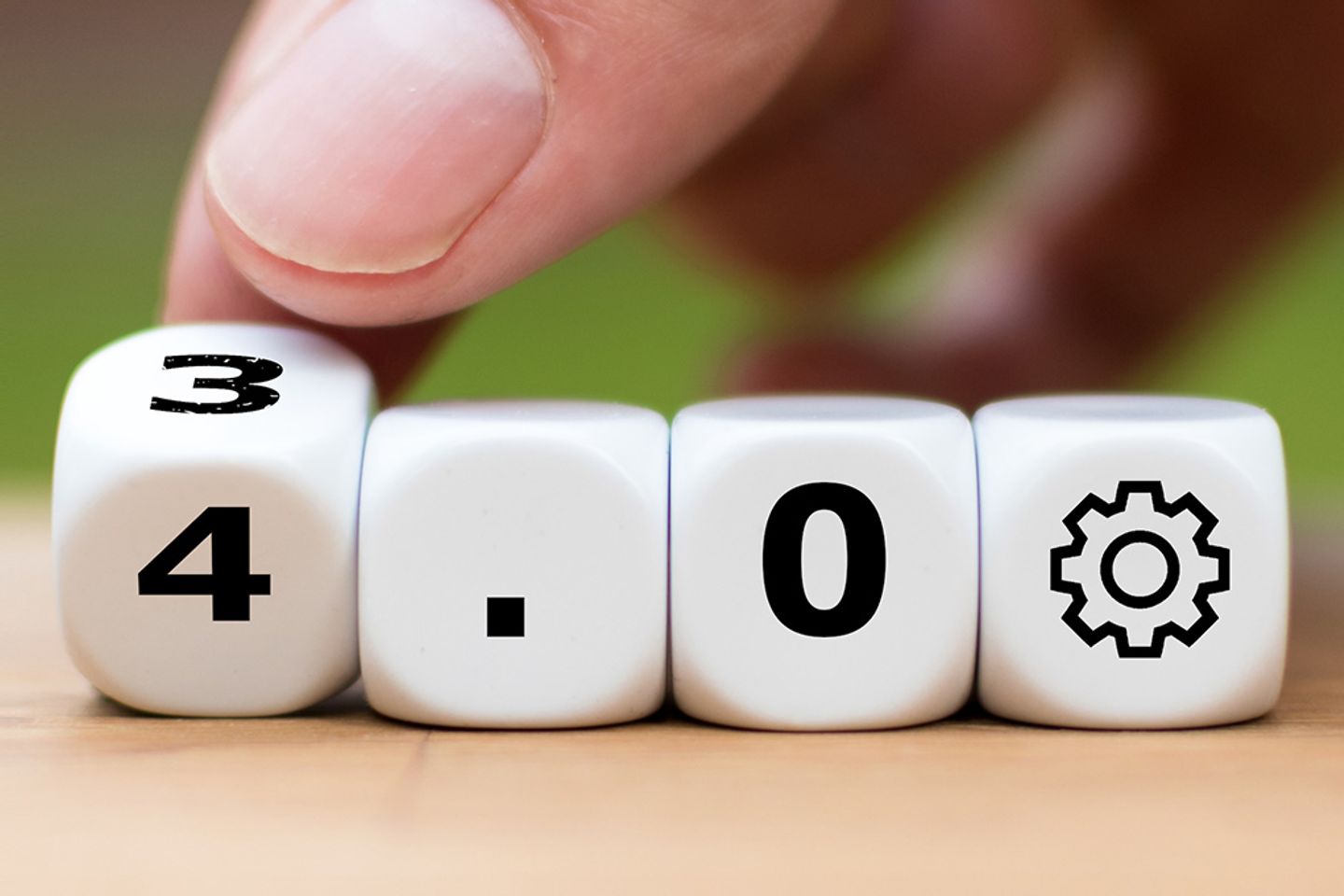 Close-up of hand turning cubes spelling out ‘3.0’ to ‘4.0’